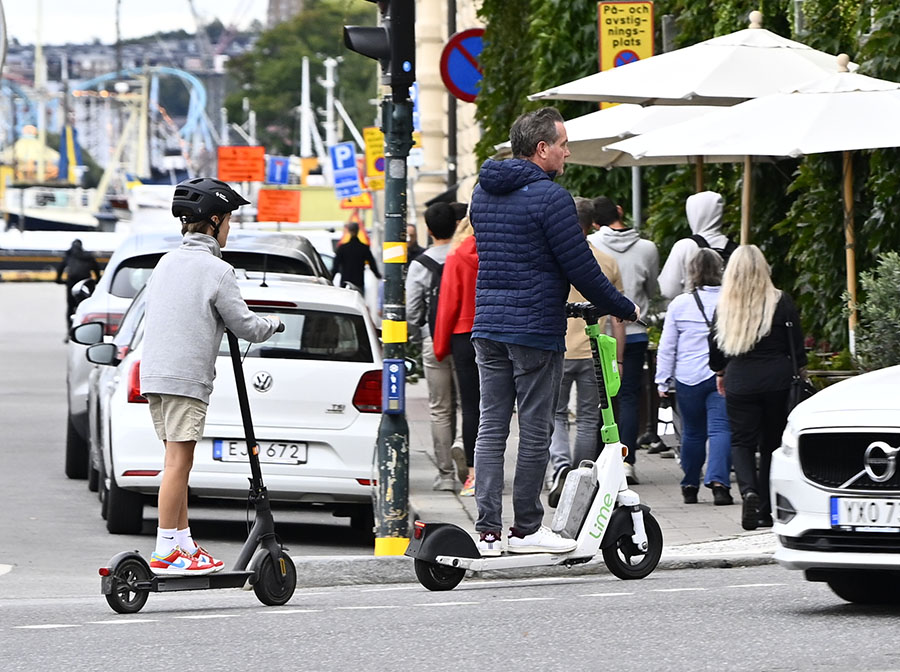 Chris O'Neills nya sportiga stil – åker elsparkcykel i Stockholm