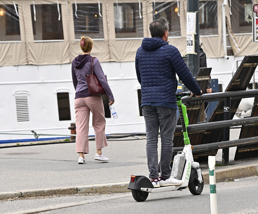 Chris O'Neills nya sportiga stil – åker elsparkcykel i Stockholm